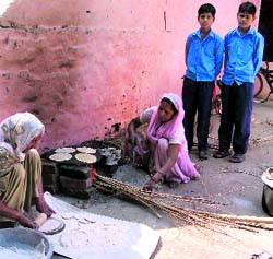 Cooking staff prepare midday meals by burning wood instead of using gas at a school in Bindrakh village of Ropar district on Monday.