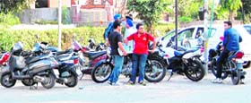 Students stand outside a private coaching centre while a number of vehicles are parked at Rani Ka Bagh in Amritsar