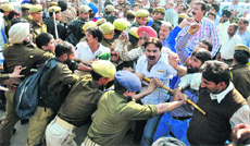 Protesting government employees being restrained by the police during a demonstration in Jammu on Tuesday.
