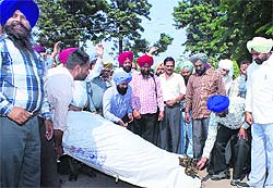 Power Corp employees burn an effigy of the management in Rajpura on Tuesday