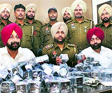 SP Bhupinder Singh Khatra shows the seized gold and silver coins at Shambhu police station