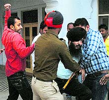 The Tribune lensman Malkiat Singh shows how a man was mercilessly beaten by a rival group in Jalandhar on Tuesday. Police presence on the spot hardly acted as a deterrent. Five persons were injured