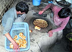 Kashmiri men prepare bread at a bakery in Habbakadal in Srinagar on Wednesday
