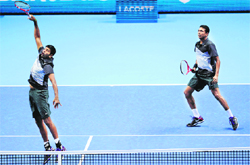 Rohan Bopanna smashes as Mahesh Bhupathi watches during their win over Robert Lindstedt and Horia Tecau.  AFP 