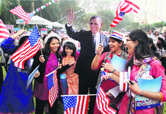 Supporters wave American flags near a cut-out of the US President Barack Obama in New Delhi.