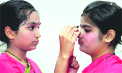 Students help each other with make-up before the start of a function at a school in Dehradun on Thursday. Tribune Photo: Vinod Pundir 