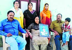 Kanta Devi, wife of Subedar Kalidass, carries his photograph in Jammu on Thursday