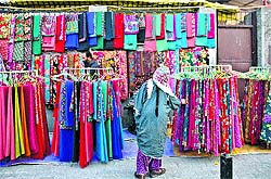 A woman selects clothes from a road side stall in Srinagar on Thursday