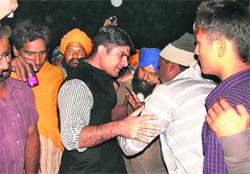 A police official (in civvies) consoles the family members of the victim. Photo: Inderjeet Verma