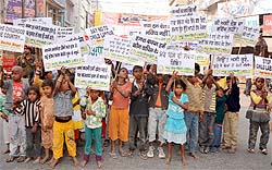 Kids studying in an evening school run by the Appu Society take out an awareness rally in Bathinda on Friday. The rally aimed at garnering support from all quarters to help poor children have an access to education. The shabbily-dressed children, many of them barefoot, walked around the city holding placards highlighting their plight