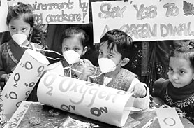 Children wear oxygen masks and display placards in support of a green Divali at Eurokids School, Sector 18, in Chandigarh on Friday.