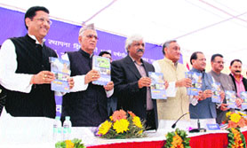Chief Minister Vijay Bahuguna flanked by his Cabinet colleagues and party office-bearers release a book on Uttarakhand in Dehradun on Friday.