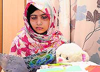 Malala Yousufzai reads cards sent by well-wishers at the Queen Elizabeth Hospital in Birmingham, England