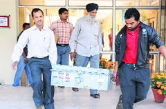 Officials carry a box containing answer sheets of the entrance exam for MD courses of the PGI in Chandigarh on Saturday. Tribune photo: Manoj Mahajan 