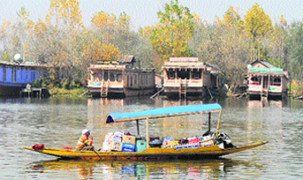 sailing for sales: A man rows his shikara containing items for sale at the Dal Lake in Srinagar. Photo: Amin War