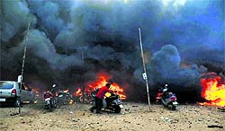 A man tries to save his scooter from fire that destroyed more than 50 fire-cracker shops in Vadodara on Saturday