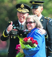 Former US Army General David Petraeus gives a thumbs-up after presenting his wife Holly with a bouquet of roses during a farewell ceremony in his honour in Arlington in this file photo.