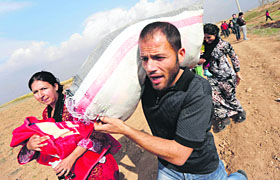 Residents flee the northern Syrian town of Ras al-Ain to Turkey on Saturday.