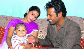 Malkeet Singh, security agent with the Haryana Police, spends time with his family at his residence in Panchkula.