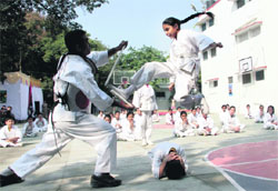 A girl performs martial arts at the annual sports day programme in Dehradun on Sunday.