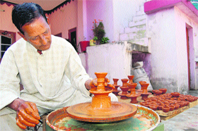 A potter makes diyas for Divali in Dharamsala on Friday.