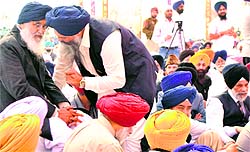 Chief Minister Parkash Singh Badal talks to SAD leader Prem Singh Chandumajra at a function in Rakhara village near Patiala on Sunday