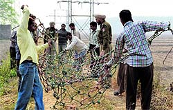 Police and forest officials arrange a net to rescue the leopard