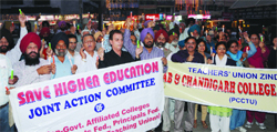 Teachers of aided colleges hold a candlelight march in Amritsar on Monday. Photo: Vishal Kumar