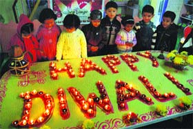Children admire earthen lamps at their school as they celebrate Divali in Shimla on Monday