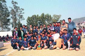 The players of MLSM Degree College pose along with SP, Mandi, Abishek Dullar after winning the HP University Inter-College Hockey Competition at Sundernagar on Monday