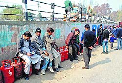 People wait in a queue to get LPG refills in Srinagar