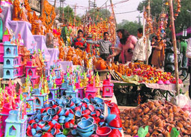 People buy diyas and candles at a market in Ludhiana on Monday.