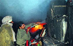 Firemen try to douse flames at a garments godown in the Field Ganj area