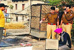 Police officials examine the spot where the man was killed at Gole market in Ludhiana