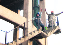 Sukhchain Singh and Amarinder Singh atop an overhead water tank in Amritsar on Thursday.