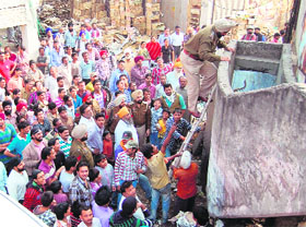 A police official climbs stairs to reach out to the youths in Amritsar on Thursday.