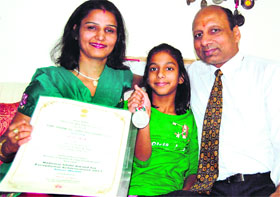Little Mehak Gupta displays the silver medal and certificate, awarded by the President of India.