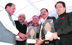 Rajeev Shukla (extreme right), who is also the commissioner of the IPL, and Sudhir Vasudeva, CMD of ONGC, being felicitated by the Chief Minister at Raipur in Dehradun on Thursday.