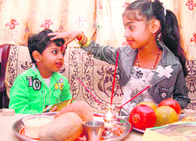A girl applies tilak on her brother's forehead on the occasion of Bhaiyya dooj in Gurgaon on Thursday. 