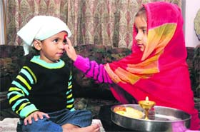 A girl puts a tilak on the forehead of her brother on Bhai Dooj in Jalandhar on Thursday