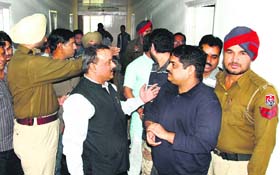Police personnel intervene to stop the fight between BJP workers at Circuit House in Jalandhar on Thursday