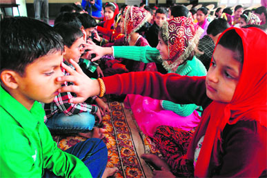 Girls apply tilak to the foreheads of boys at an orphanage on the occasion of Bhaiya Dooj in Jammu on Thursday.