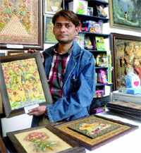 Suraj, a mural artist from Faridabad, displays his work in Haryana pavilion at Pragati Maidan during the IITF-2012 in New Delhi on Friday