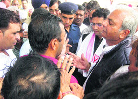 Chief Parliamentary Secretary Prahlad Singh Gillankhera (right) and MP Ashok Tanwar (standing next) try to persuade villagers at Bisla in Fatehabad district on Friday.