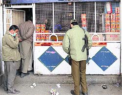 Policemen inspect a liquor shop in the Heemal hotel complex which was targeted by militants on Thursday