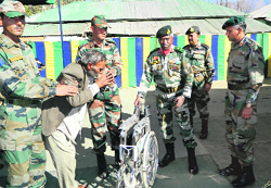 Army officials give a wheelchair to a needy person at a medical camp in Machhedi block of Billawar tehsil in Kathua district on Friday. A Tribune photograph