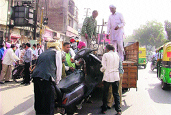 Officials of the Tehbazaari Wing of the Municipal Corporation load a wrongly parked two- wheeler in a truck near Bharat Nagar Chowk in Ludhiana on Friday. Photo : Inderjeet Verma