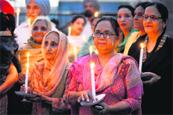 Retired teachers of government-aided colleges hold a candlelight march at Model Town Extension in Ludhiana on Friday. Tribune photo: Himanshu Mahajan