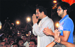 Shiv Sena executive president Uddhav Thackeray with son Aditya interacts with his supporters in Mumbai.