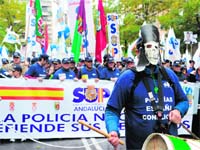 Spanish police officers hold banners of the Unified Police Union (SUP) as they take part in a demonstration in front of the interior ministry to express their anger at the Spanish government's latest austerity measures and benefit cuts in the centre of Madrid on Saturday